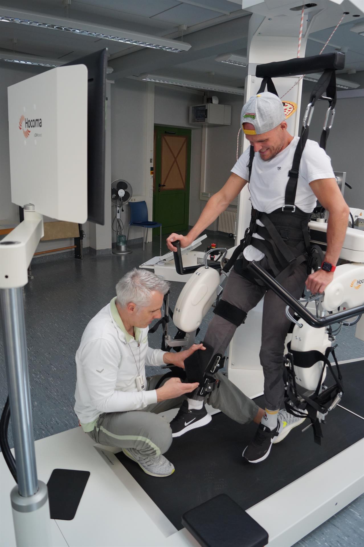 ein Patient wird für das Training im Lokomat Pro von einem Physiotherapeuten vorbereitet