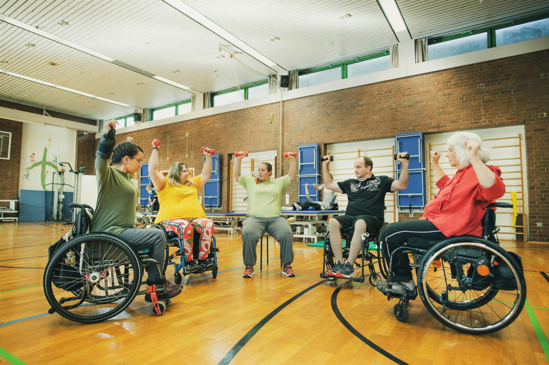 Eine Gruppe Rollstuhlfahrer machen Fitness im Rollstuhl