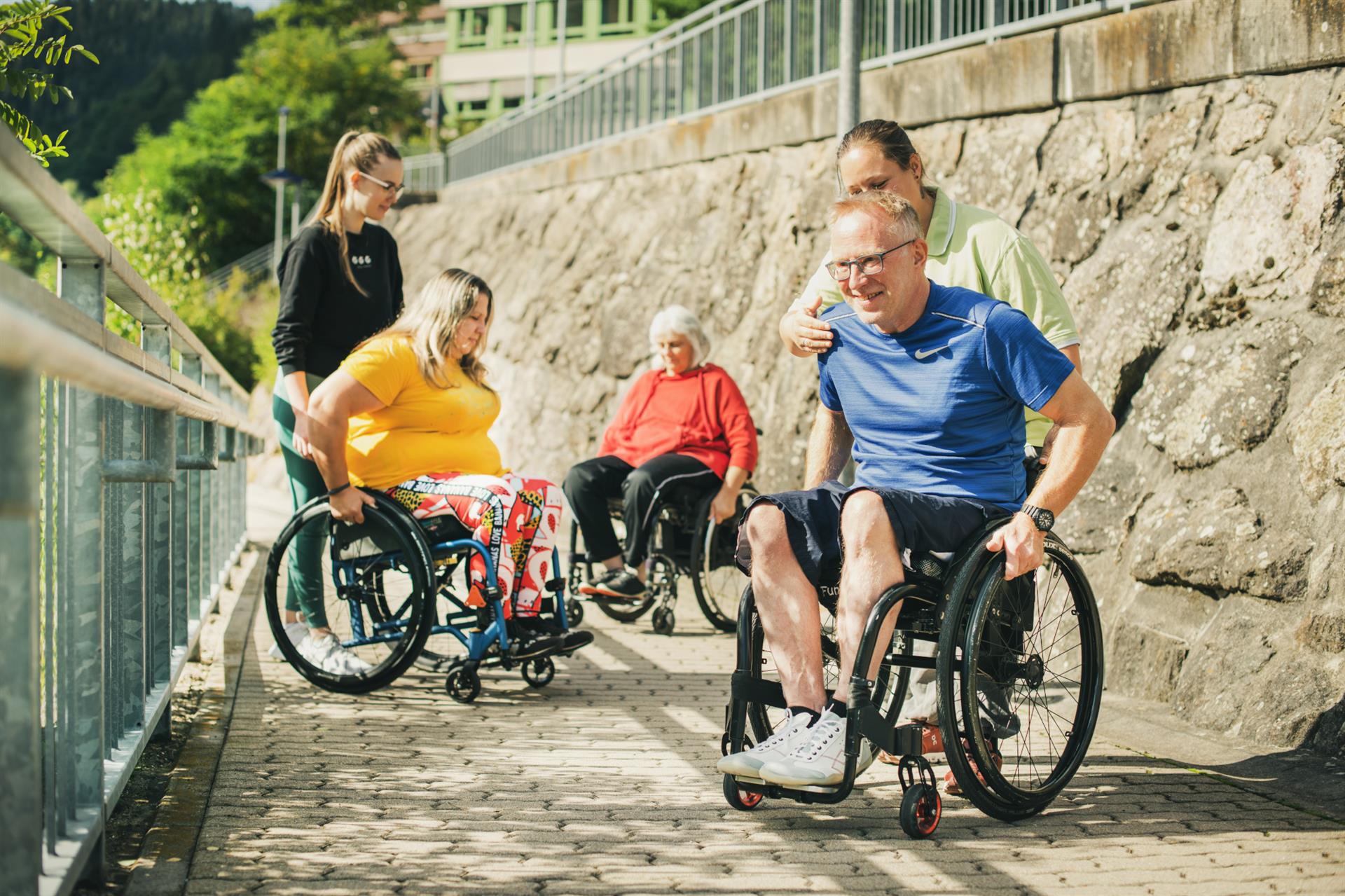 Eine Gruppe Patienten im Rollstuhl beim Mobilitätstraining im Freien